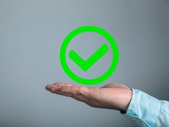 green tick inside green circle hovering above open palm